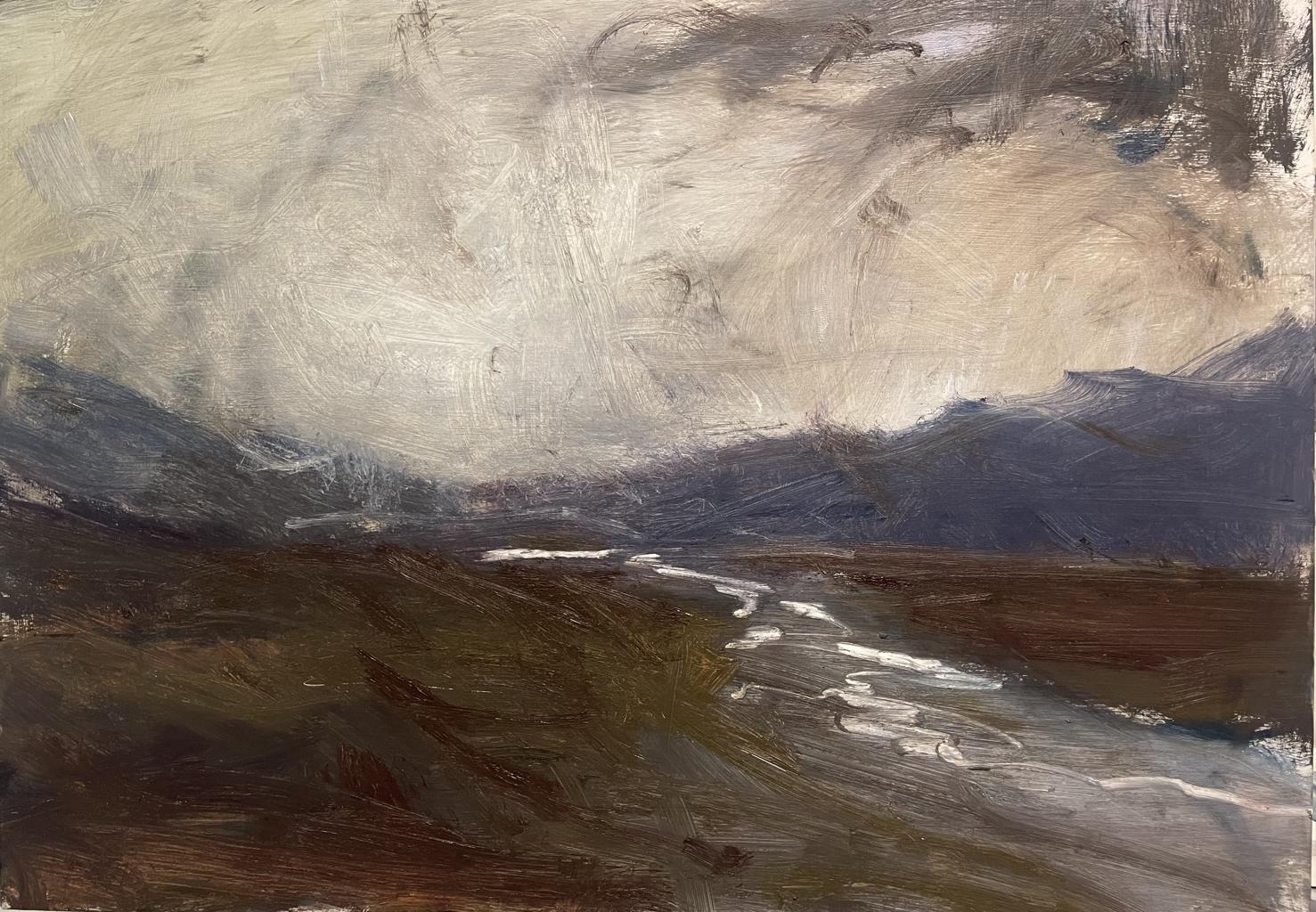 brown landscape with a large grey road cutting through and dark grey mountains