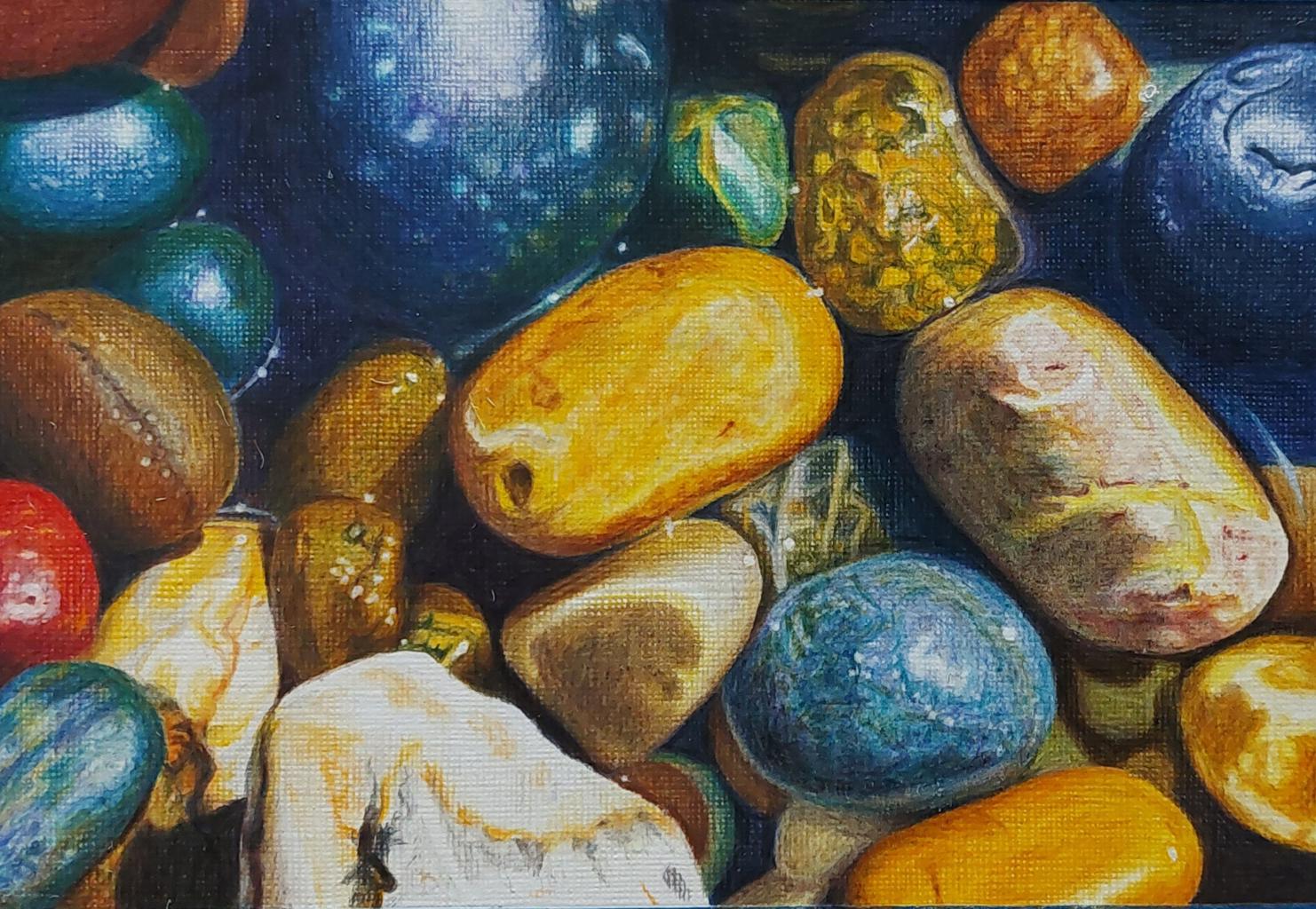 a close up of colourful pebbles on a beach.