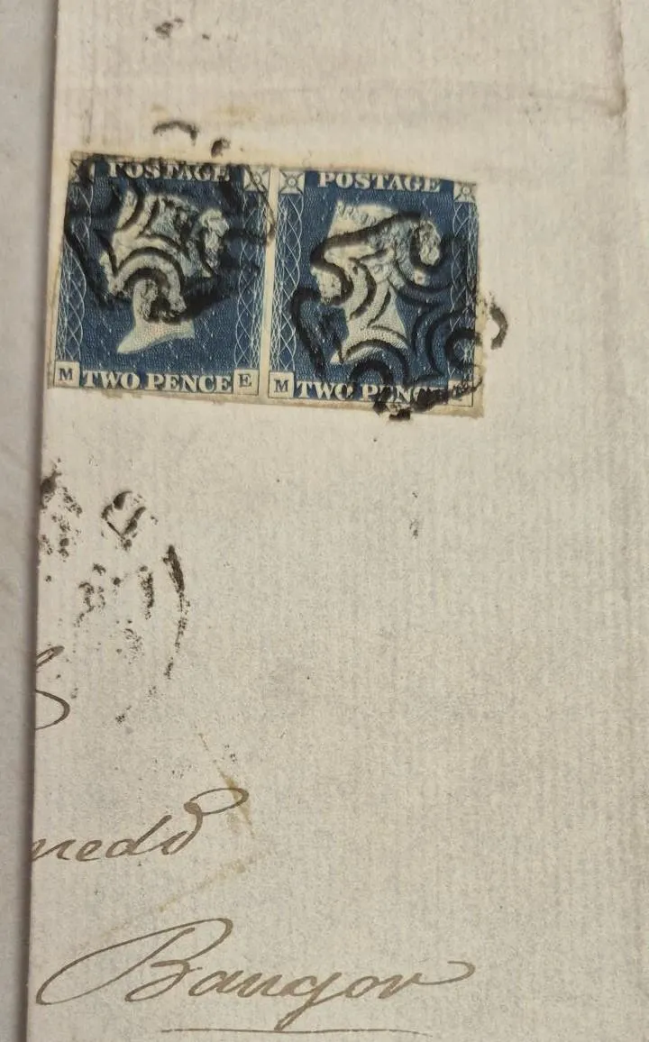 A photograph of an envelope with two stamps in the front.