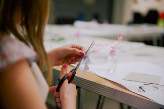 Photograph of a child cutting paper with scissors.