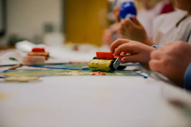 A child using a roller and paint.