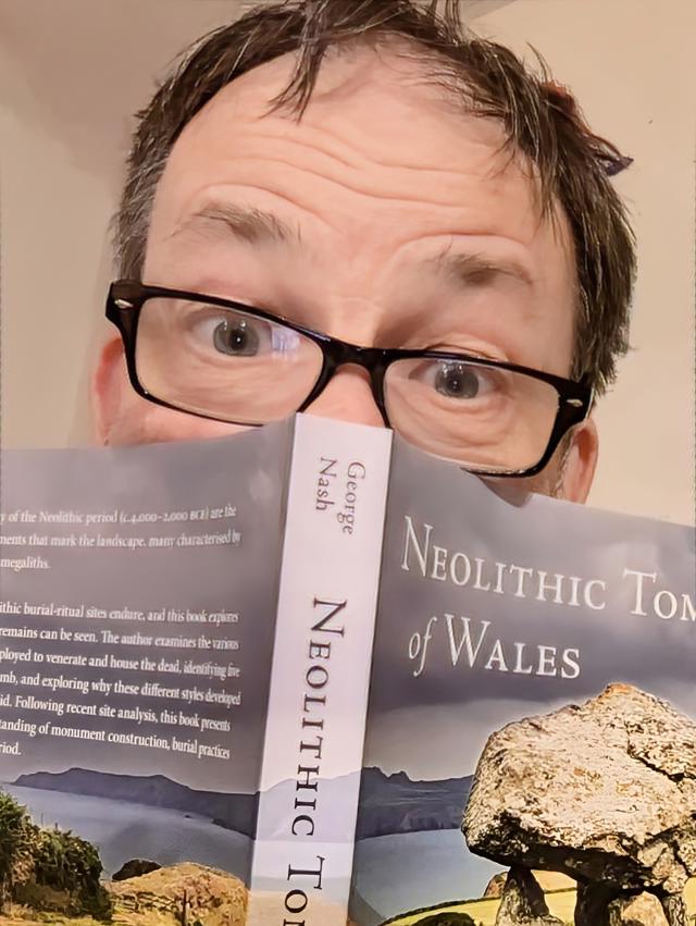 Photograph of George holding his book.