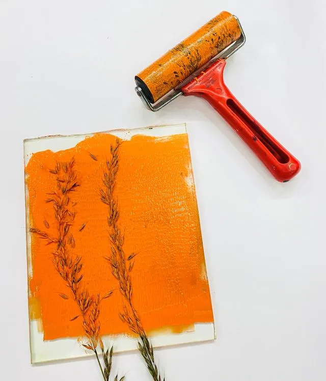 Ffotofraff o blodau wedi ei brintio ar bapur gwyn yn defnyddio paent oren