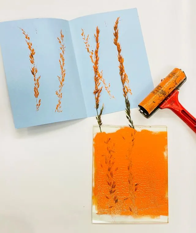 A photograph of flowers printed on a piece of paper using orange paint