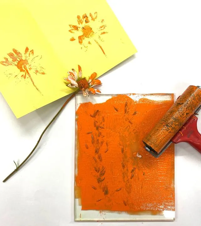 A photograph of flowers printed on a piece of paper using orange paint