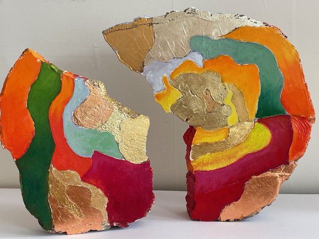 wooden block cut in half painted with colourful strips and gold