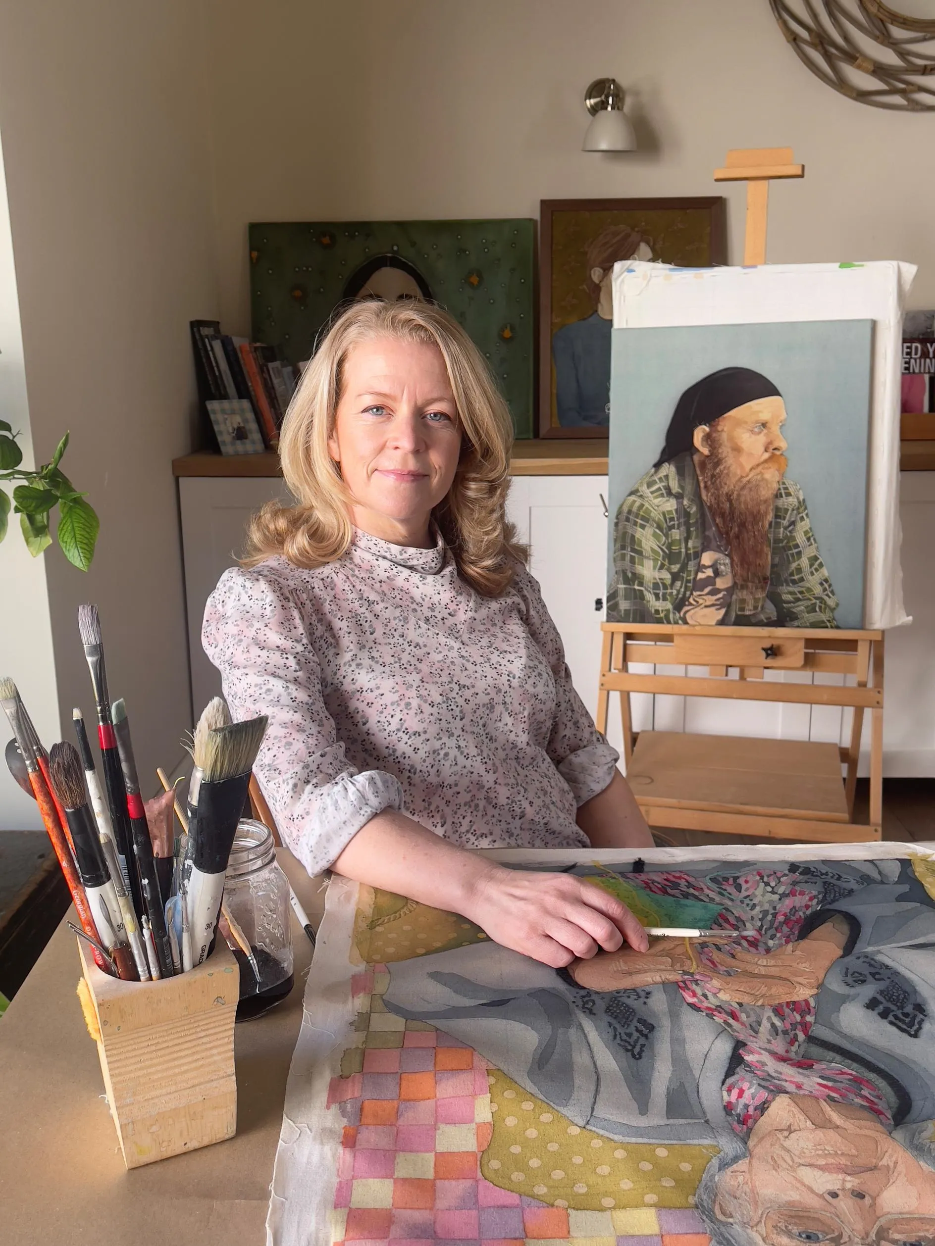 Ffotograff o Celia Hume yn eistedd yn ei stiwdio