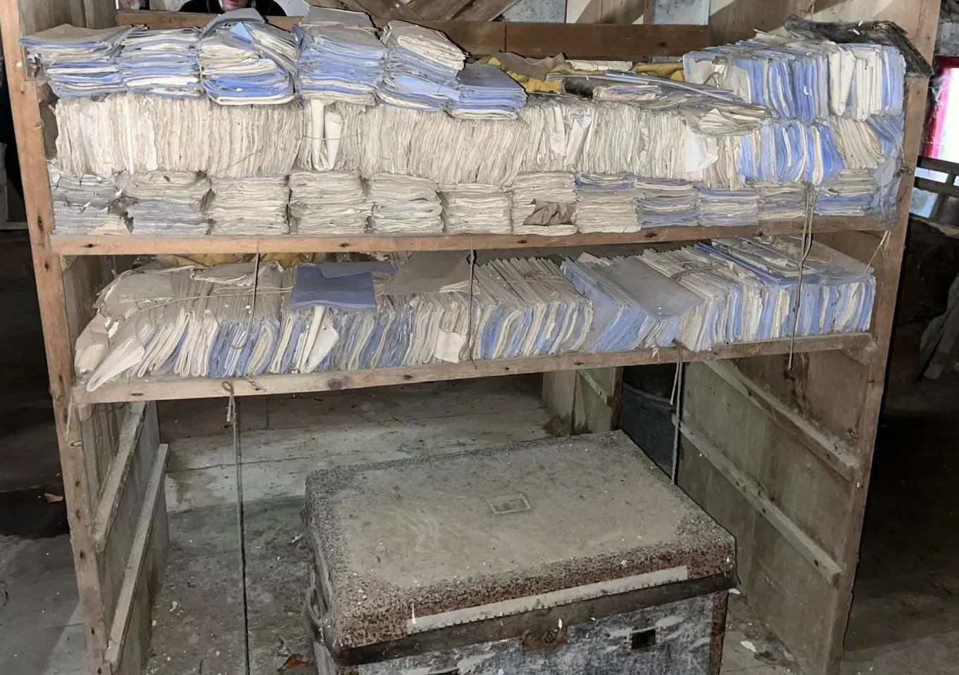 A photograph of old documents stored in a barn